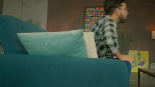 Close Up Young Man with Glasses Sitting on Sofa Take Tablet Computer at Home Thinking Communication