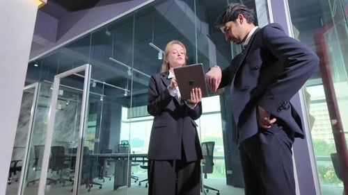 Business meeting in modern office between two professionals discussing documents