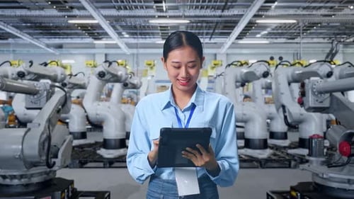 Woman Working with Tablet in Robotics Factory
