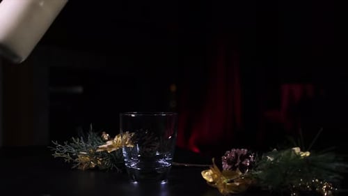 A female hand pouring chilled Christmas Eggnog into a glass