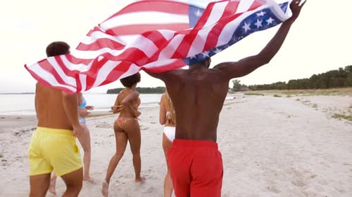 Friends Running on Beach Waving American Flag