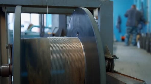 Close up of automated winding the cable on the drum. Creative. Industrial cable production factory.