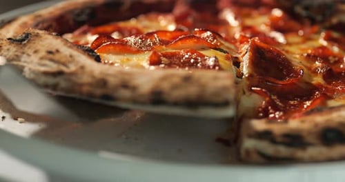 Pepperoni Pizza Being Cut and a Slice Removed