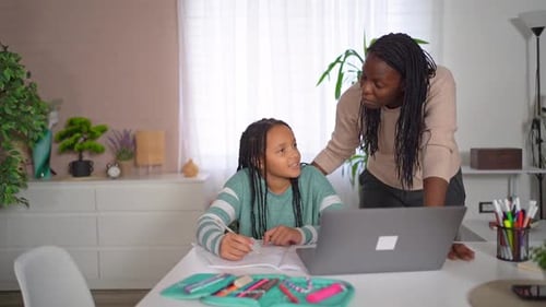 Woman Helping Girl with Homework at Home