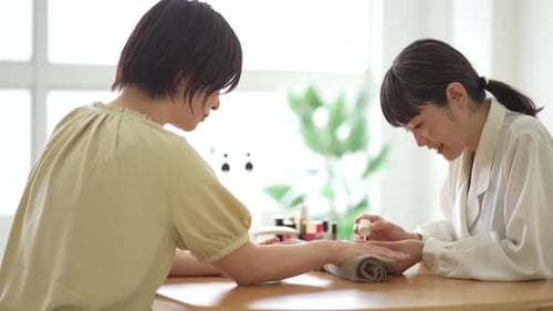 Woman Applying Nail Polish to Another Woman's Nails