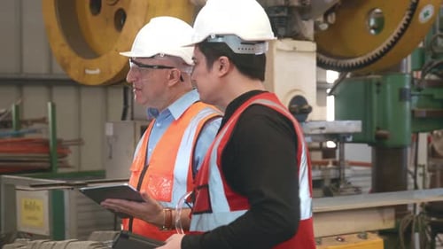 Engineer teaching apprentice to use metal sheet stamping machine