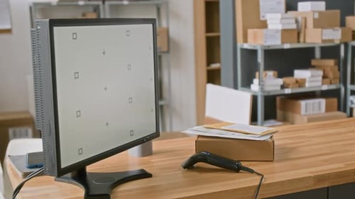 Computador, leitor de código de barras e pacote no balcão do escritório de entrega expressa