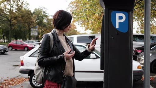 Woman Using Parking Meter on City Street