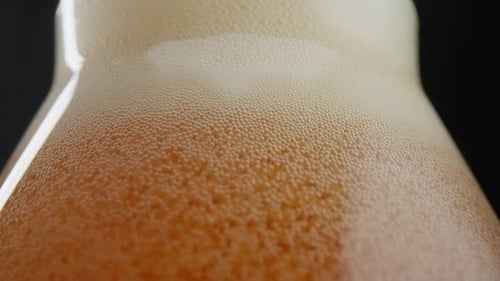 Close-up of beer being poured into a glass with a lot of bubbles