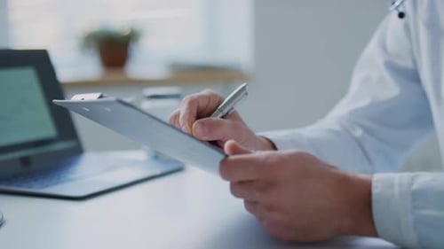 Doctor Writes on Clipboard in Office Setting