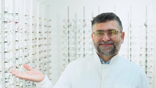 Retrato de un oftalmólogo senior seguro de sí mismo con gafas en una tienda de óptica