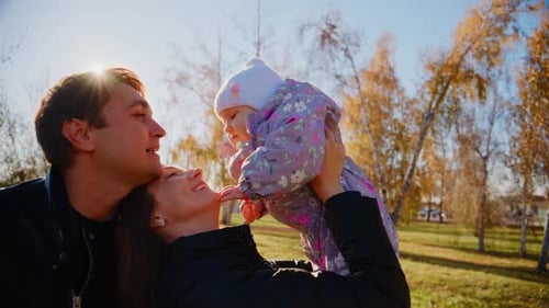 A Joyful Family Moment in Nature Parents Cherish Their Baby in a Sunny Outdoor Park Creating Lasting