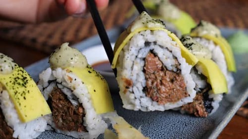Take Sushi Sticks and Dip Them in Soy Sauce at a Japanese Restaurant Variety of Types of Sushi with