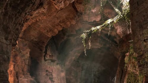 Sunlight Filters Through a Rocky Archway in a Secluded Cave During Daytime