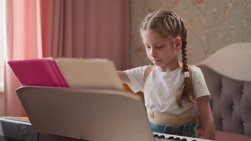 Young Girl Practices Piano at Home