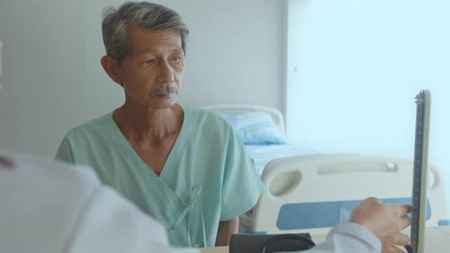 Asian senior male patient is consulting and visiting doctor in hospital.