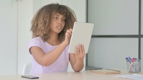 Young Adult Using Tablet at Desk