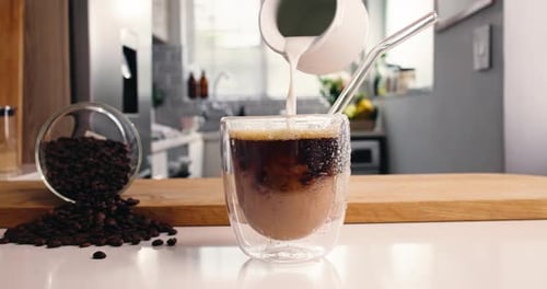 Preparing Iced Coffee with Milk in Kitchen