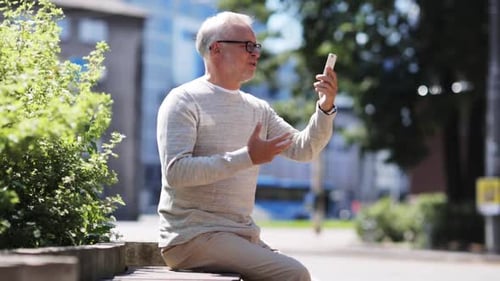 Senior Man Using Smartphone on Bench in City