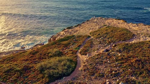 Drone Stay and Approach Rocky Island Shores and Sea Waves at Sunset Portugal
