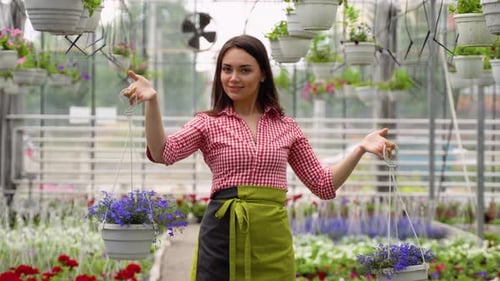 Woman Holding Flowers in a Tropical Greenhouse