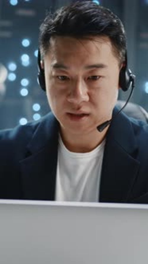Close Up Asian IT Developer Administrator Wearing Headset Speaker Using Laptop Computer Server Room