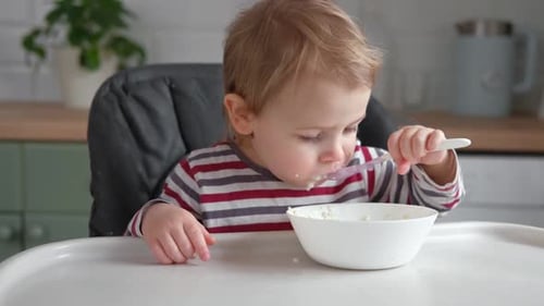 Adorable Child Eats Food in Kitchen