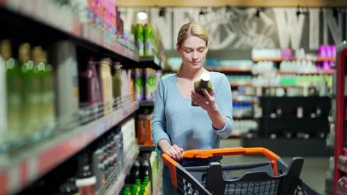 Female chooses and examines product on the supermarket shelves. household chemicals or body care