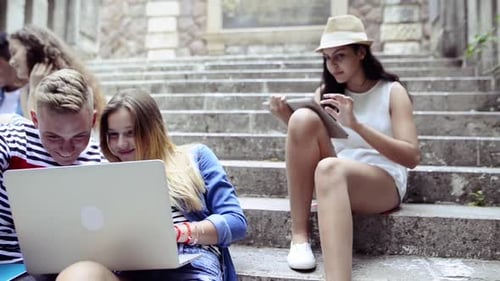 Teens Studying Together on Steps with Laptops