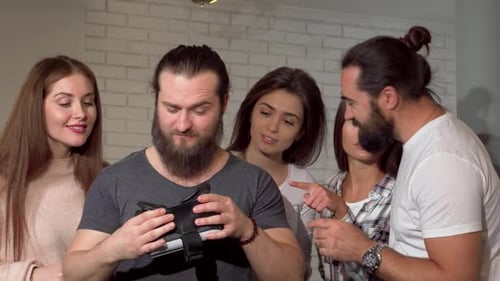 Friends Watching Man Using Virtual Reality Headset