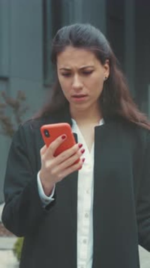 Businesswoman Checks Phone Woman in City Promptly Examines Alarming Alert Displayed on Her Mobile