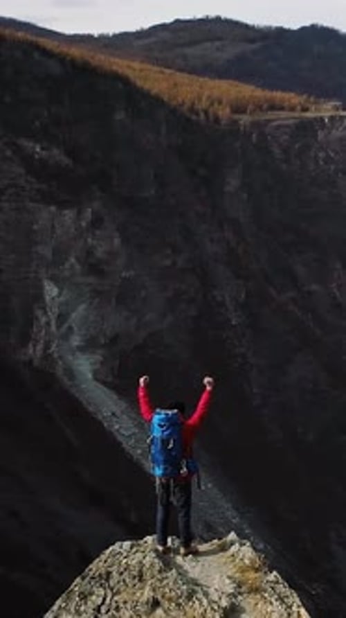 Hiker Celebrating Reaching Mountain Peak with Arms Raised