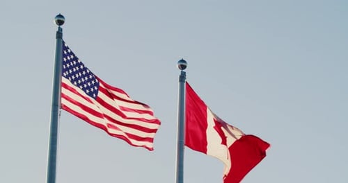 American and Canadian Flags Waving
