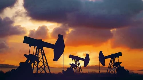 Industrial Oil Pumpjacks Silhouettes Operating Against Dramatic Sunset Sky