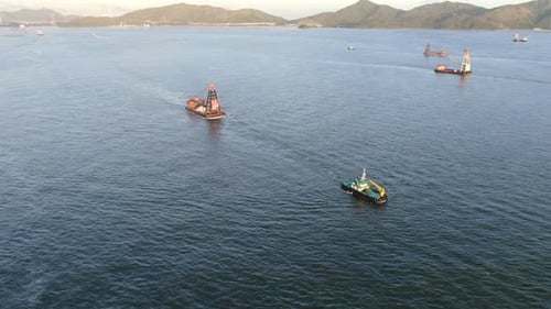 Tugboat pulling a small Barge in Hong Kong bay, Aerial view.