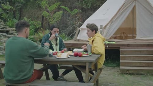Friends Enjoying Food at Campsite Picnic Table
