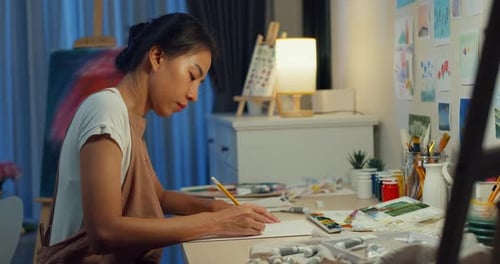 Asia lady drawing picture on sketchbook create artwork cozy workshop in home at night.