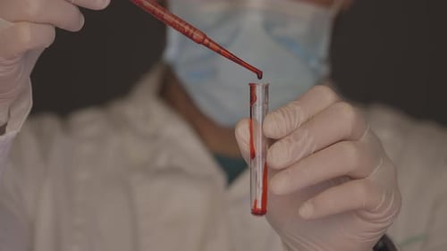 Technician Puts Liquid into Test Tube in Laboratory
