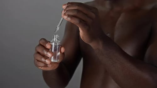 Person with Dropper over Bottle