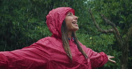 Woman Smiling in Rain Wearing Red Raincoat