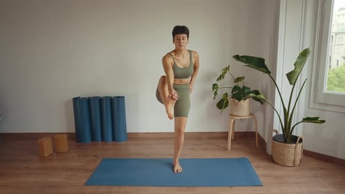 Woman Practicing Yoga Exercise on a Mat