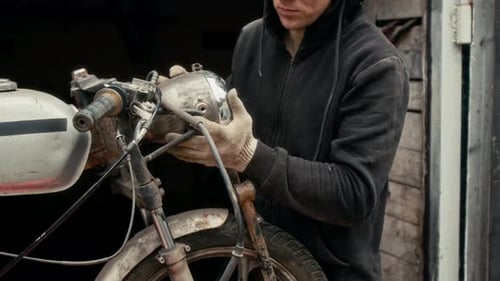 Mecánico que instala faros en una motocicleta vintage hecha a medida