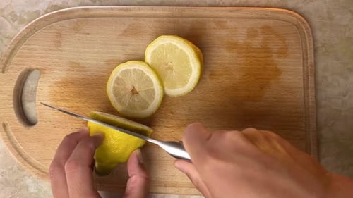 Pov Process of Slicing Yellow Lemon on Wooden Kitchen Board at Home