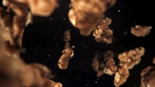 Falling Walnuts in Slow Motion Against Black Background