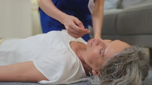 Une aide-soignante asiatique sauve la vie d'une femme âgée en faisant de la réanimation cardio-respiratoire en cas d'urgence.