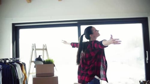 Woman with arms outstretched in bright new home