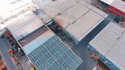 Large industrial zone with metal hangars and tanks. Huge country area with village houses