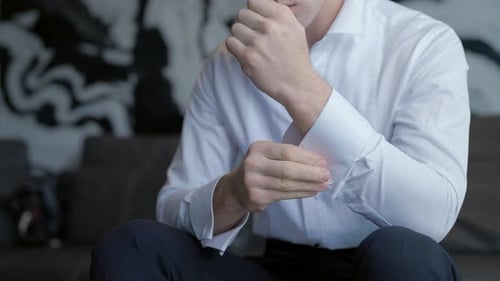 Young Adult Man Buttoning Shirt Cuff