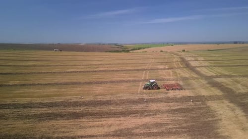 Tractor working on the field doing tillage with cultivator
