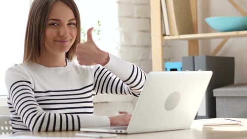 Woman Working on Laptop Gives Thumbs Up